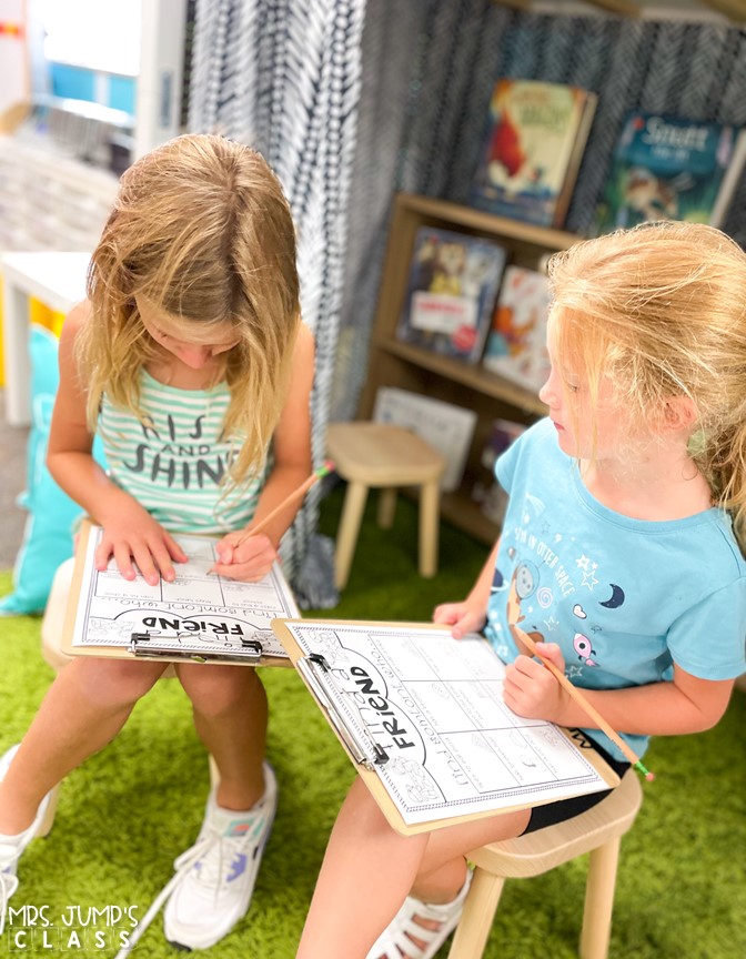 Two girls sit on chairs with clipboards, completing a "Find a Friend" activity