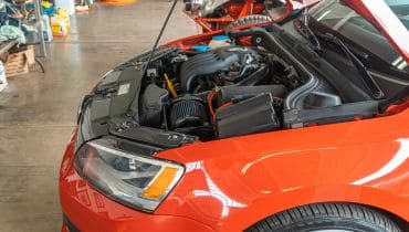 Close-up of a car engine in a workshop setting.