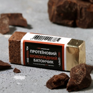 Протеїновий батончик Foodera «Шоколадний» 50 г — фольгована упаковка з зображенням шоколаду на світлому фоні.