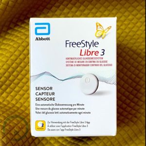 Сенсор FreeStyle Libre 3 закріплений на задній частині руки користувача, компактний і майже непомітний, передає показники глюкози на смартфон у реальному часі.