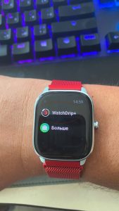 Розумний годинник з червоним ремінцем на руці, дисплей з додатком WatchDrip+ та часом 14:59.