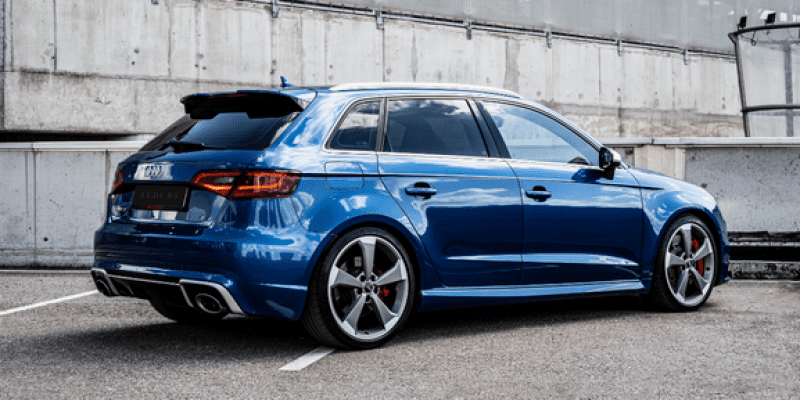 Blue Audi station wagon parked on city street, side view.