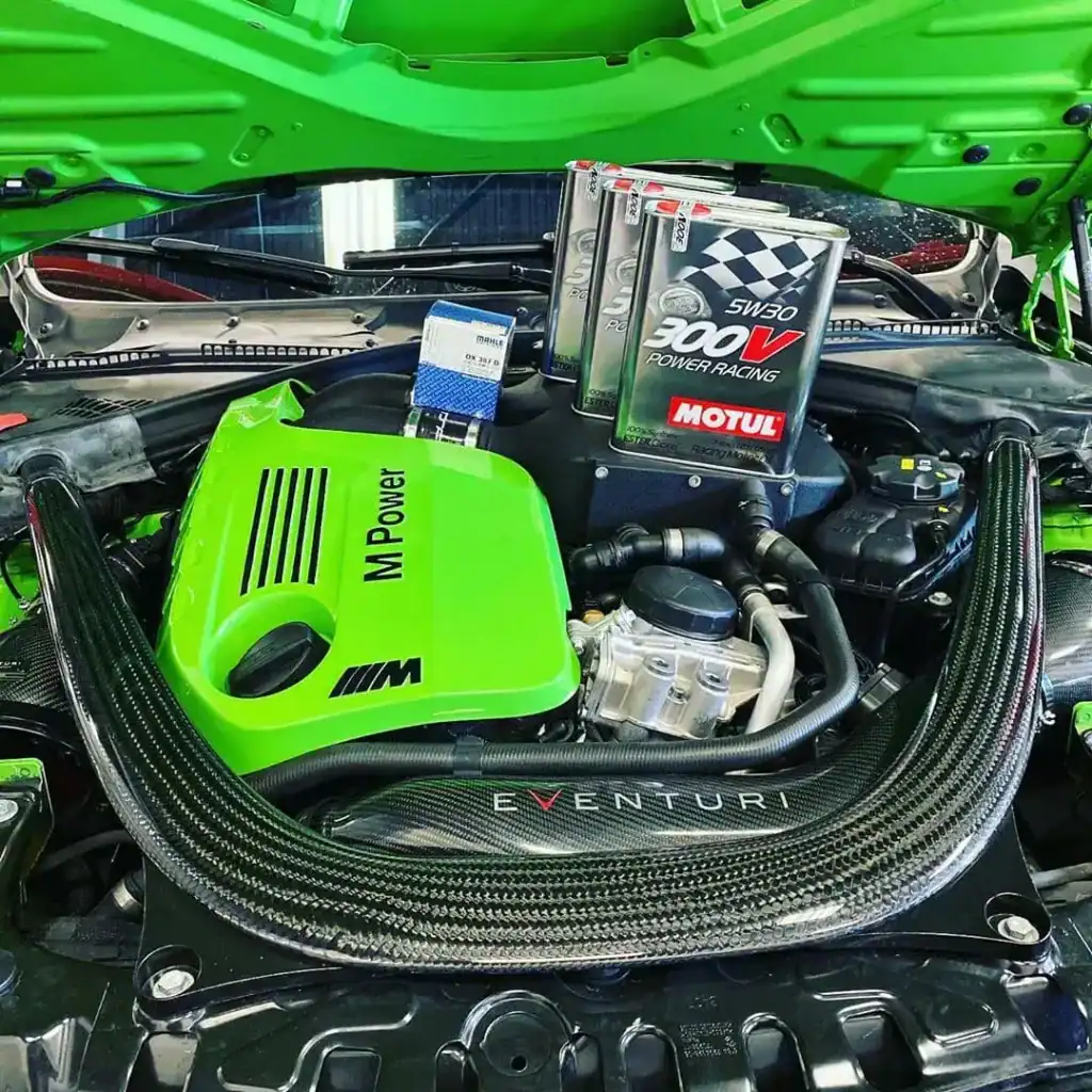 High-performance car engine with Motul oil and green accents.