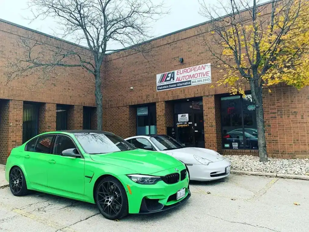 Bright green BMW M3 parked outside European Automotive dealership.
