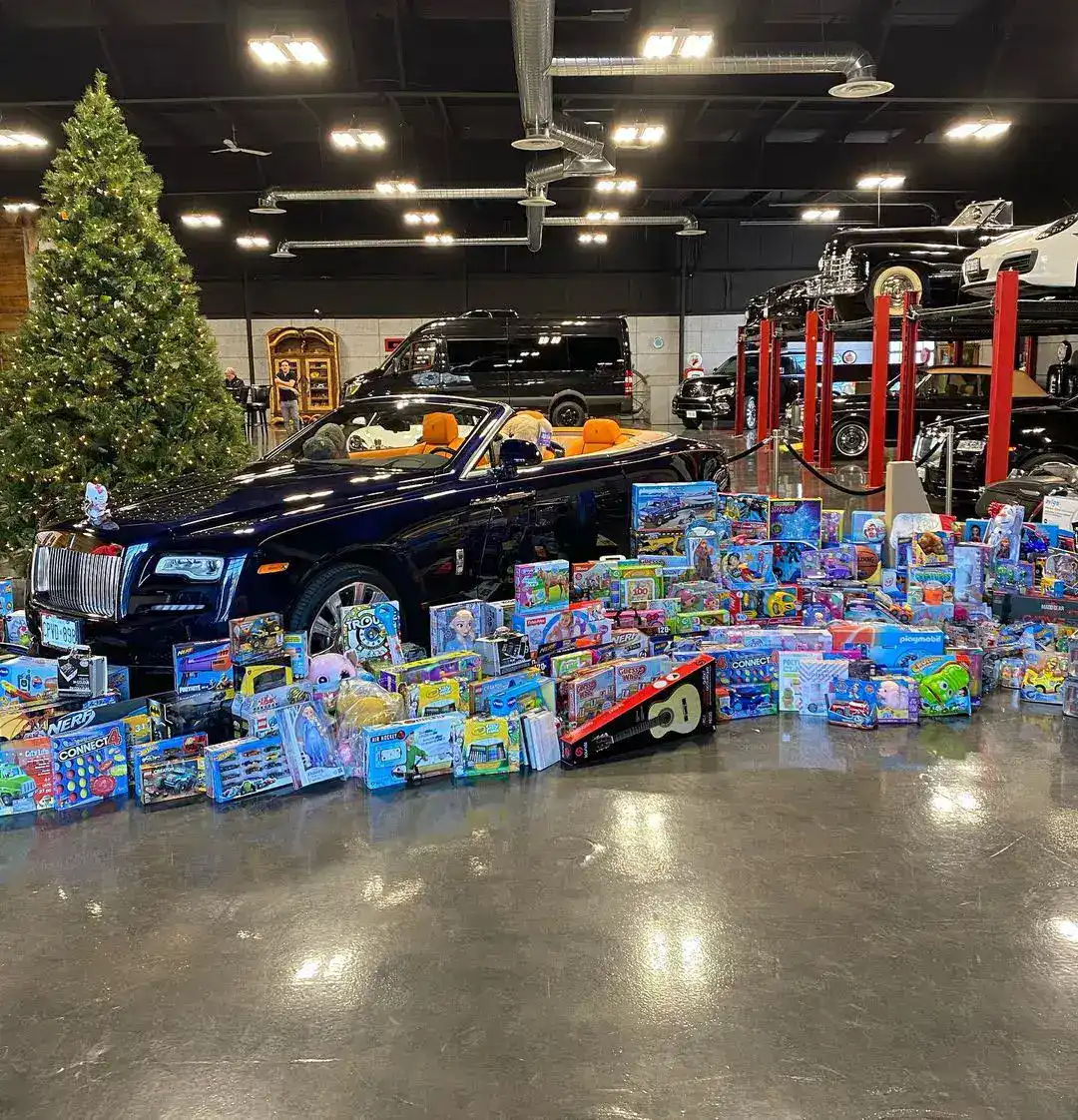 Luxury car surrounded by Christmas toys at Autostrada Magazine event.