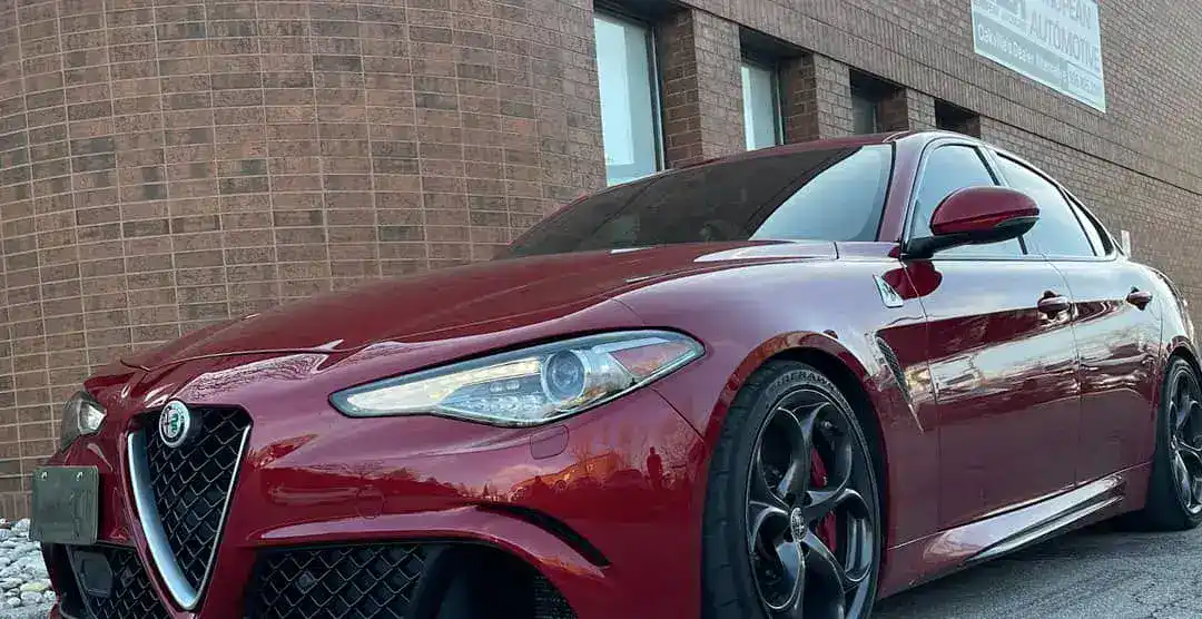 Red Alfa Romeo sports car parked outside a building.