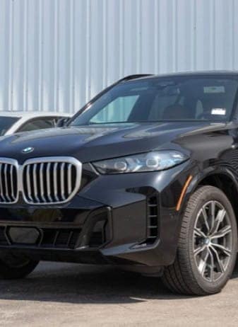 Black BMW SUV parked outside a dealership or garage.