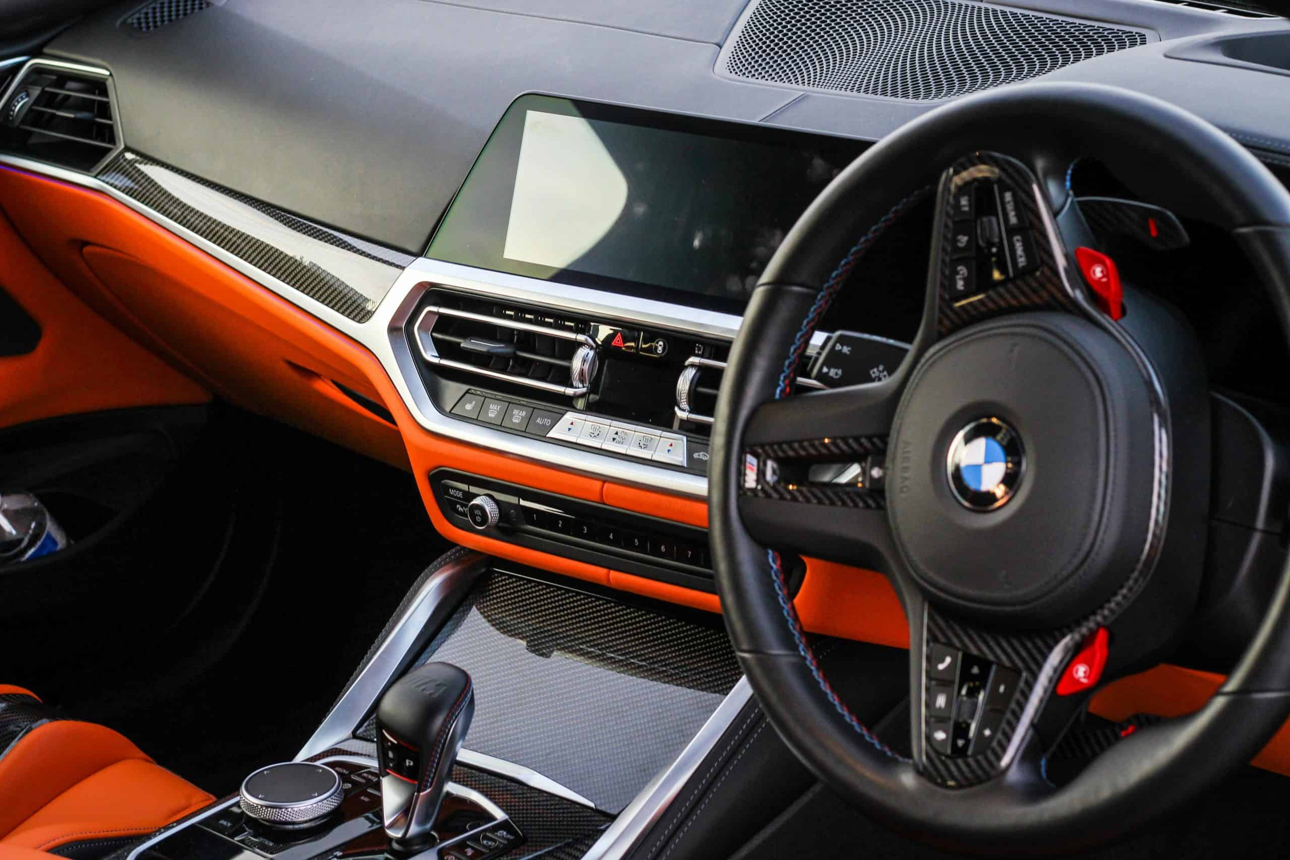 Modern BMW car interior with advanced dashboard and steering wheel.