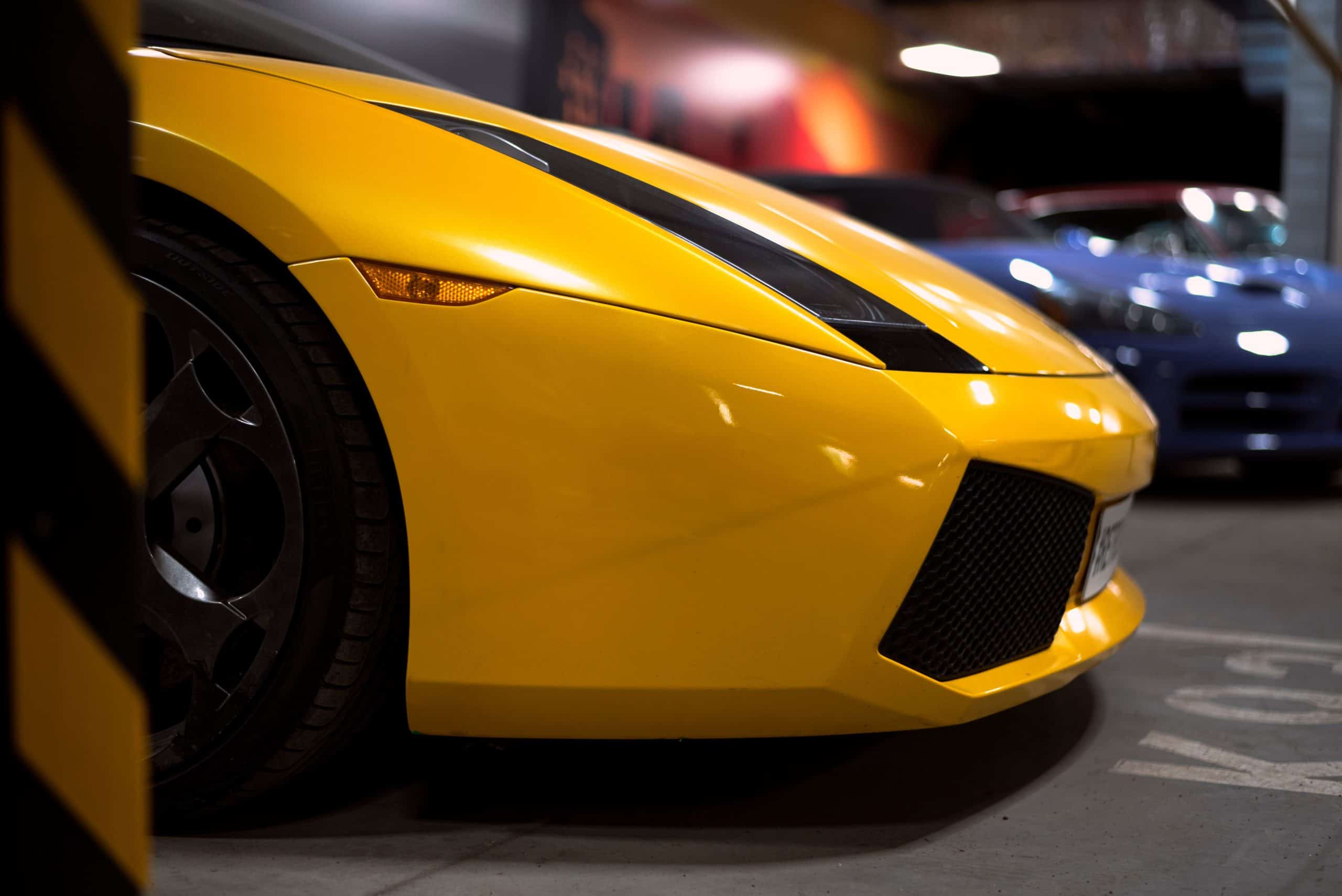 Close-up of a yellow Lamborghini sports car in a parking garage.