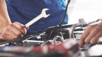 Auto repair technician fixing car engine in Dallas, TX.