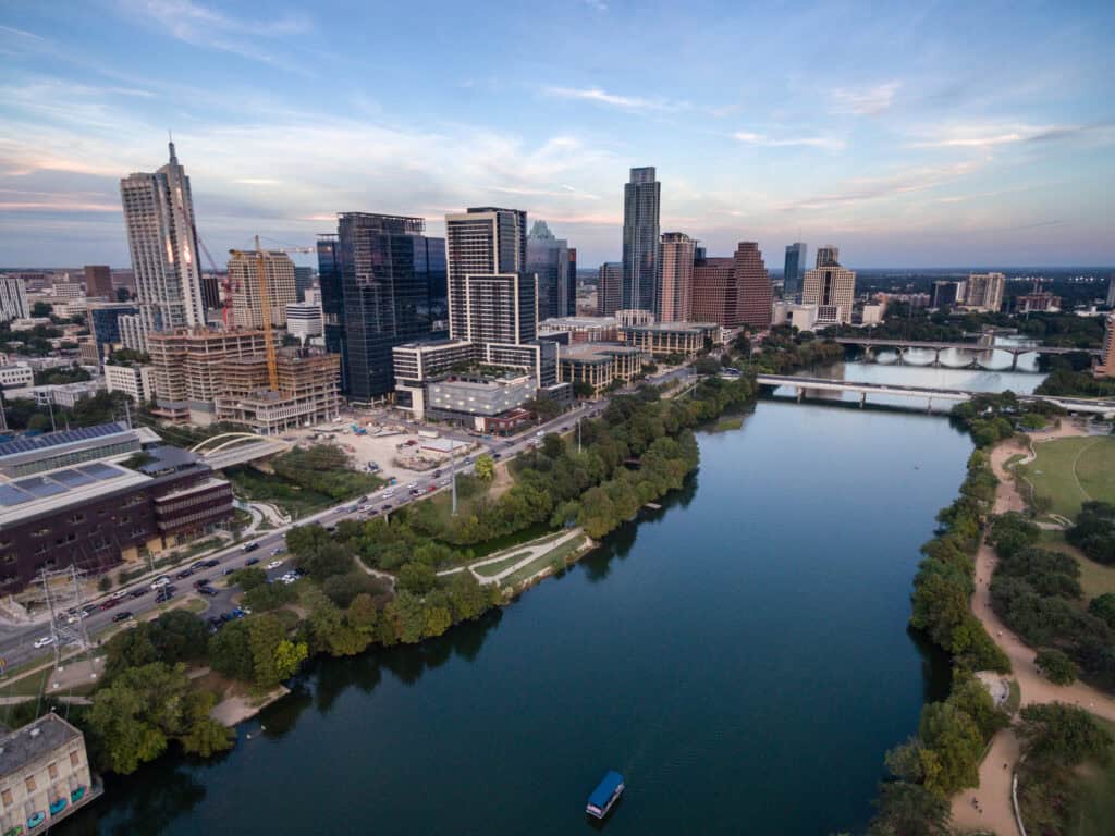 Austin, Texas skyline with downtown buildings and Lady Bird Lake in the foreground.