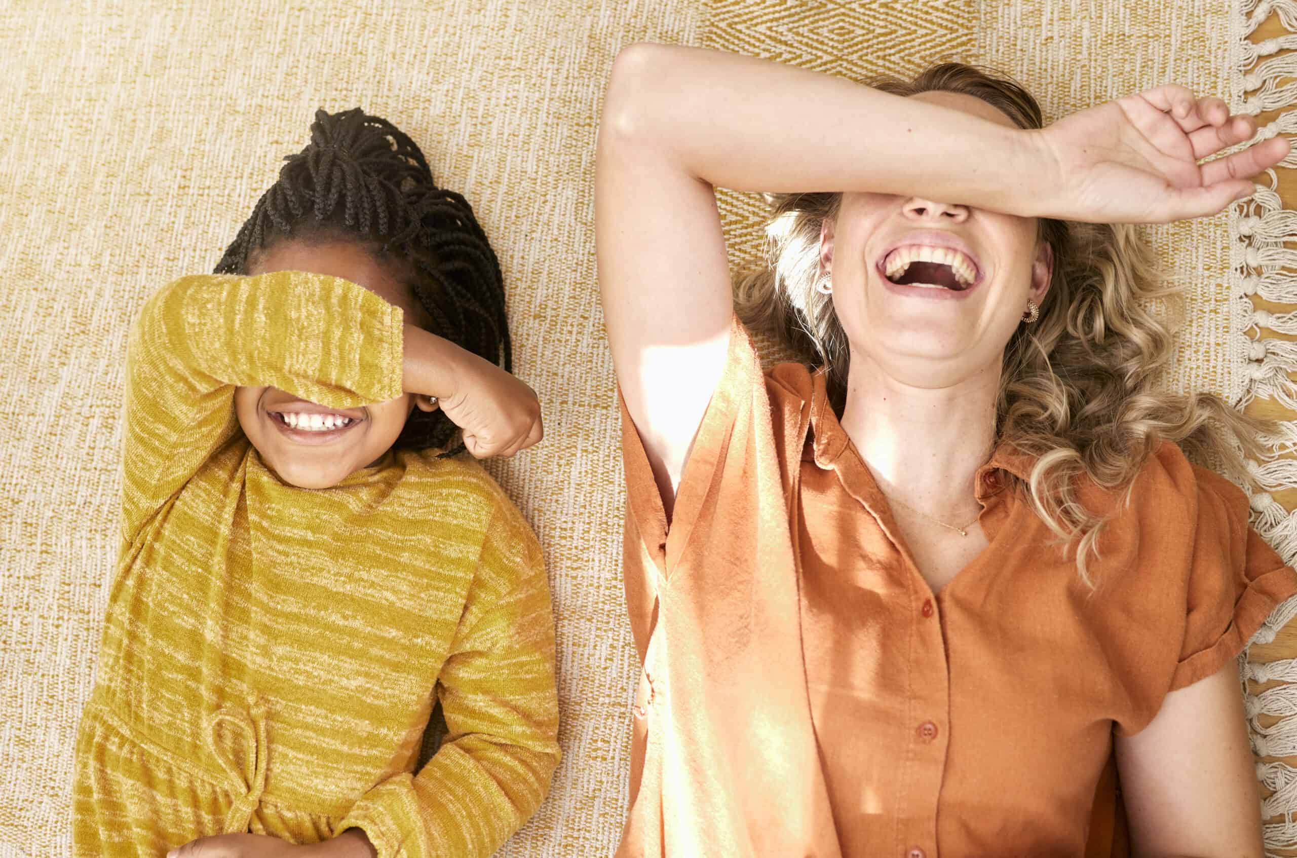 Happy women and girl lying on the floor, smiling and enjoying a joyful moment together.