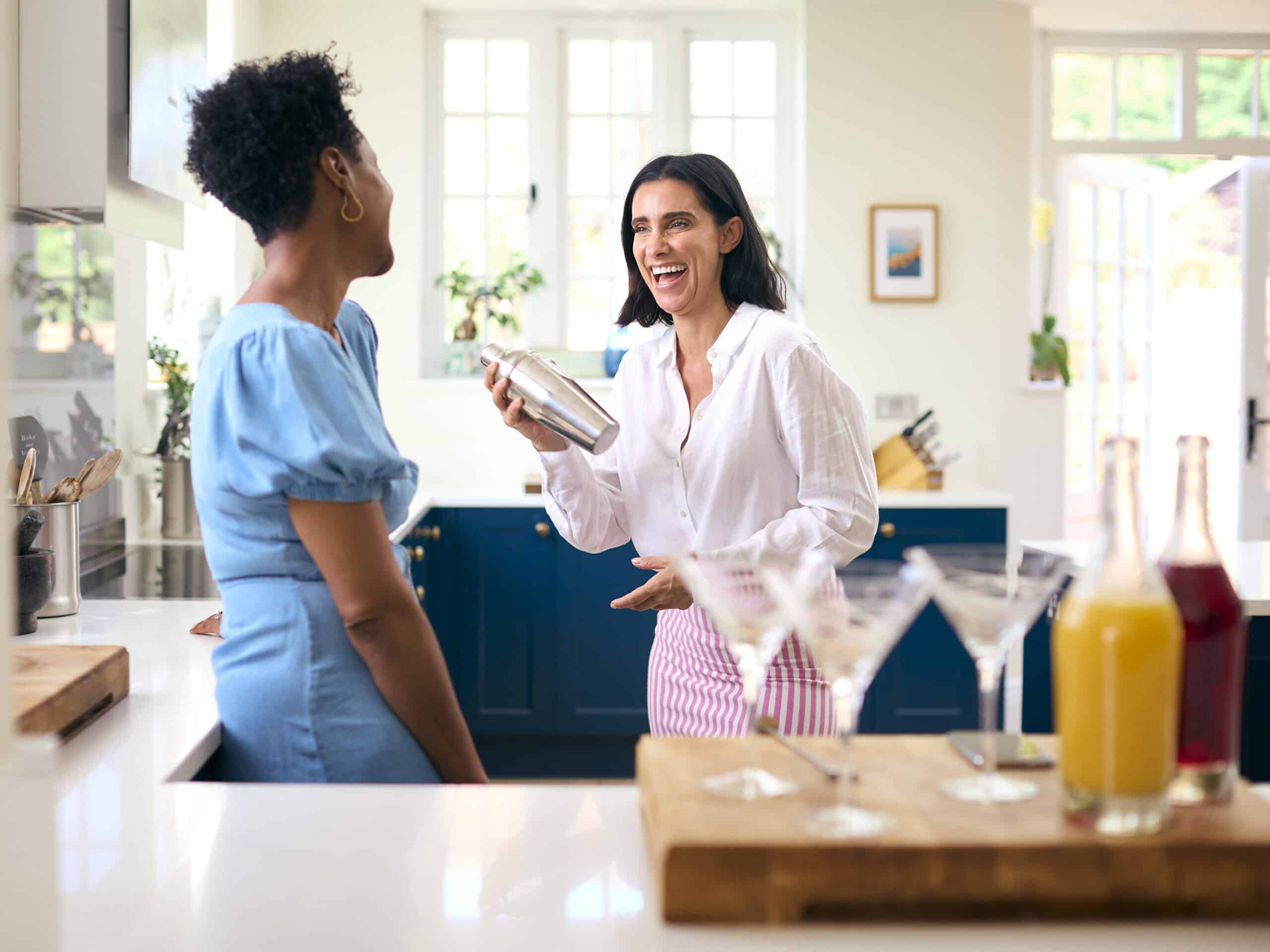 Two women enjoying a cooking class in a bright, modern kitchen.