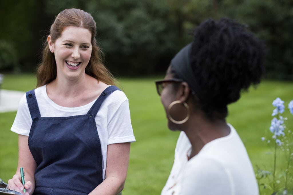 Two women smiling and talking outdoors in Leander, Texas, enjoying a healthy lifestyle.