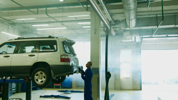 Skilled technician inspecting a vehicle during auto body repair at HeVtech.