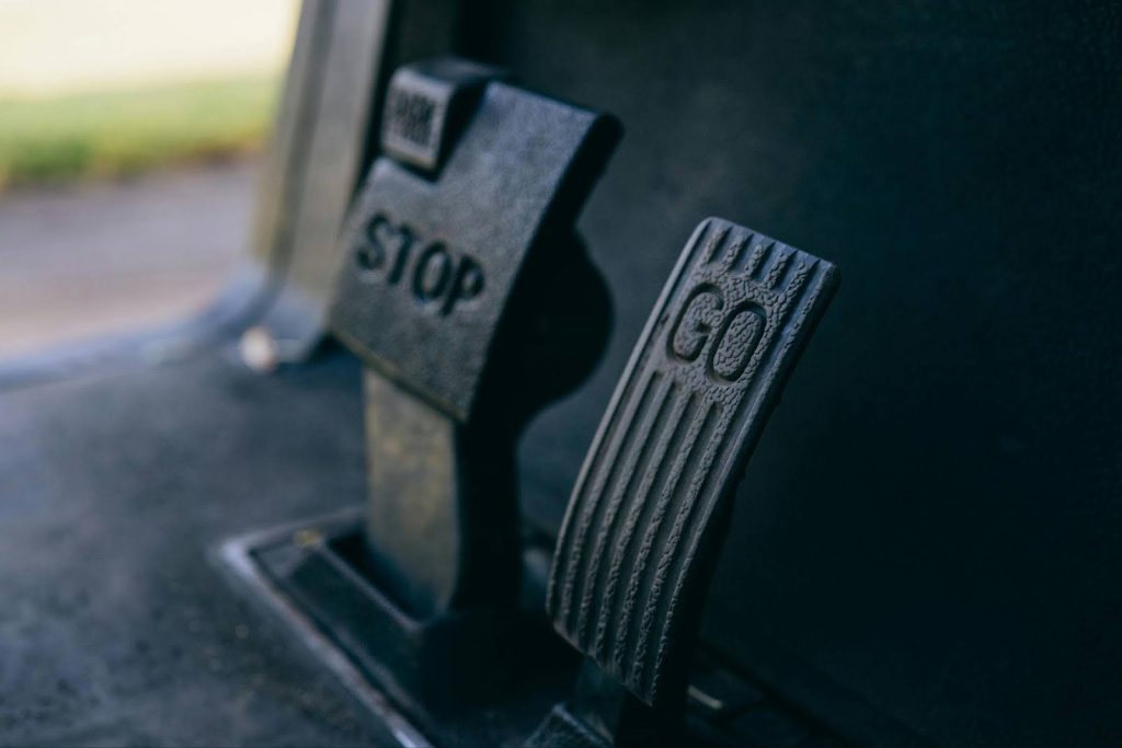Vehicle transmission pedals with "STOP" and "GO" labels, highlighting transmission control issues.