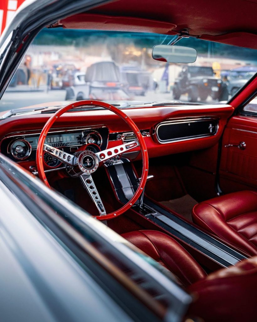 Vintage car interior featuring red leather seats and a classic dashboard, ideal for car enthusiasts.