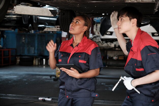 Auto mechanics inspecting vehicle brakes in a service bay.