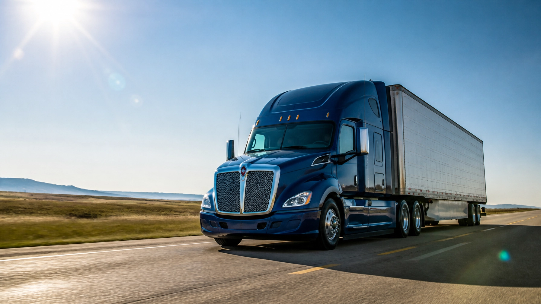 Blue semi-truck on open road with clear sky, tire service focus.