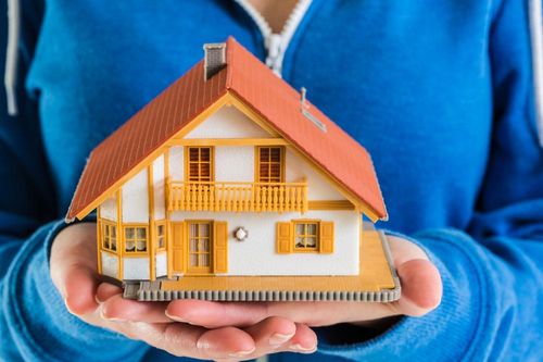 Hands-holding-miniature-house-model