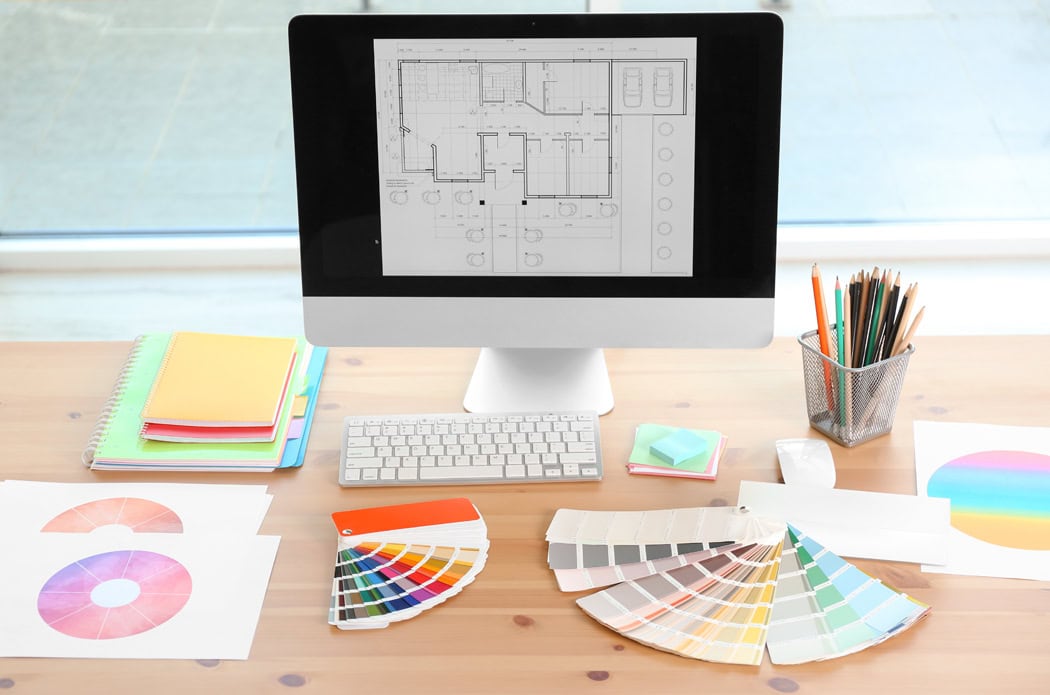 Designer’s workplace with computer and paint color palette sampl