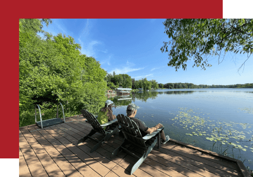 two people sitting on dock by lake