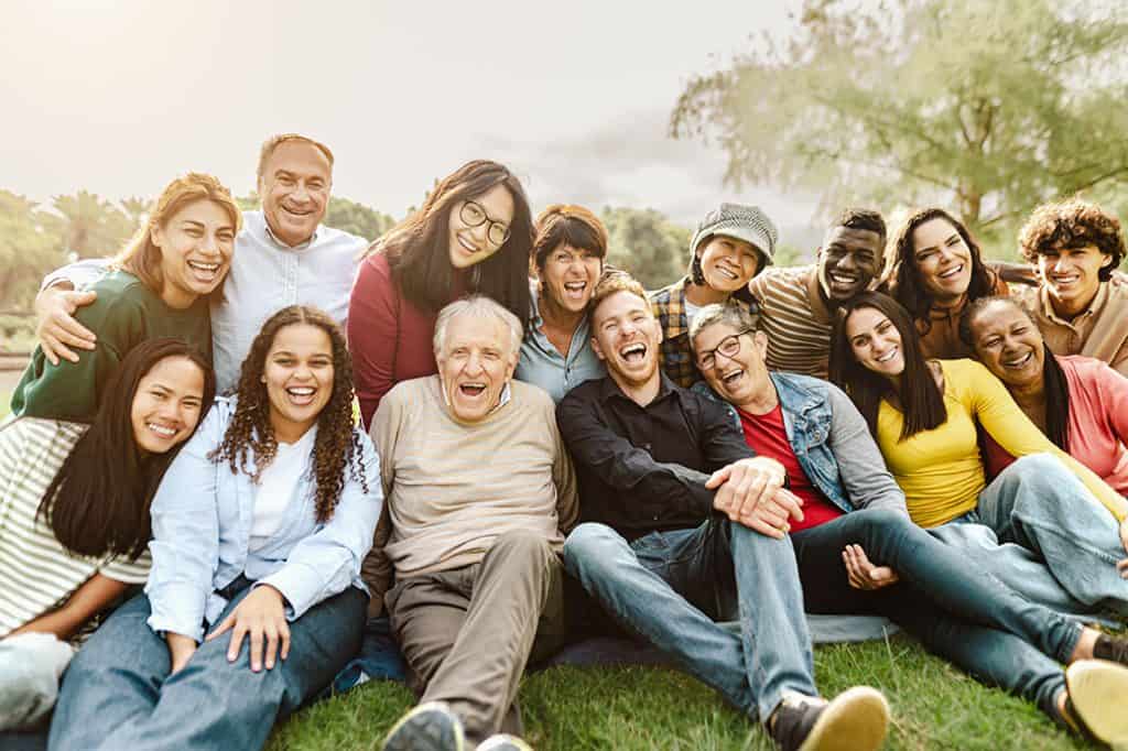 Happy Multigenerational People Having Fun Sitting On Grass In A