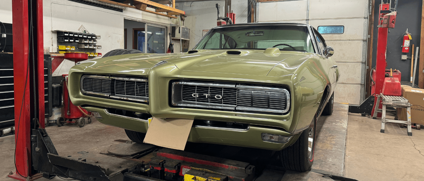 Restoring a vintage green muscle car at John's Auto Restoration shop.
