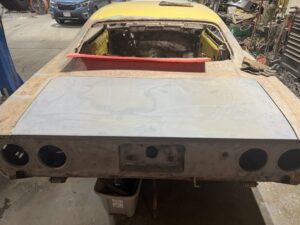 Classic car undergoing restoration in workshop.