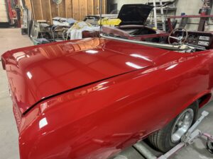 Classic red convertible car being restored at John's Auto Restoration shop.