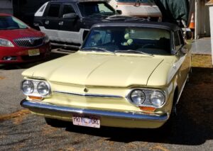 Vintage yellow classic car with restored bodywork and chrome details at John's Auto Restoration.