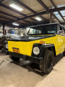 Yellow Jeep vehicle inside John's Auto Restorations workshop.
