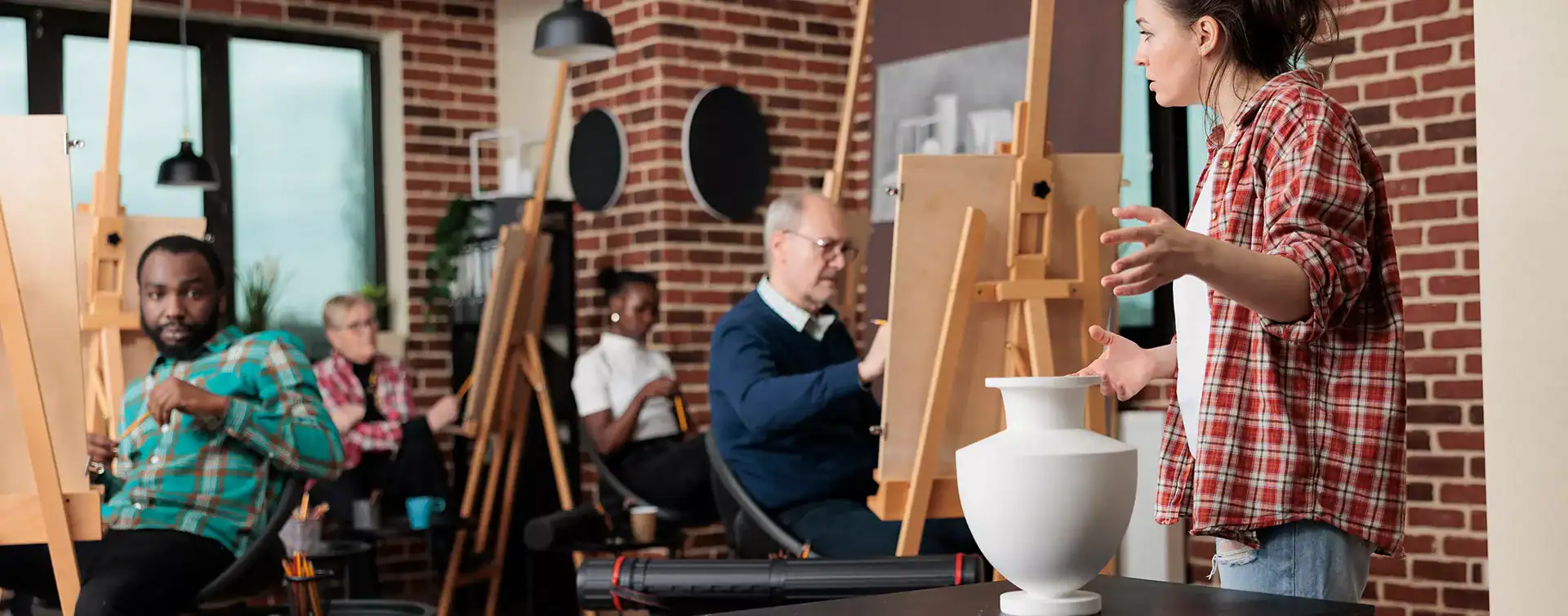 Creative art class with diverse students painting in a modern studio.