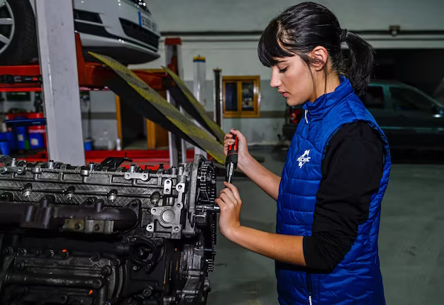 Female mechanic working on a car engine repair