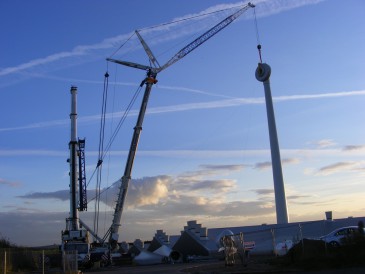renewables first - Final fixing of the wind turbine generator as the sun goes down.