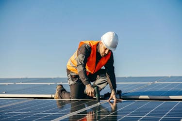 commercial solar power installation -Roof mounted solar PV panels being secured to the fixing rails