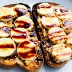 Buttered toast topped with sliced bananas, peanut butter, and drizzled with chocolate syrup, healthy breakfast, simple fresh food ideas, nutritious snack, delicious toast recipe.
