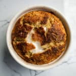 Creamy garlic herb baked dip served hot in a white ramekin, featuring a golden brown crust and smooth interior, perfect for appetizer or snack.