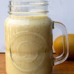 Creamy lemon vinaigrette in a glass jar with fresh lemon in the background, perfect for salads and healthy eating.