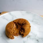 Crispy vegan fried delicious stuffed with melty cheese and savory caramelized onions on white marble plate.