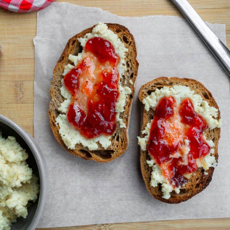Cream cheese flavored toast with mashed potatoes and tomato ketchup, fresh bread slices on parchment paper, wooden table surface — simple, homemade breakfast or snack idea, perfect for comfort food lovers.
