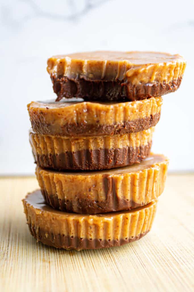 Butterscotch caramel brownies stacked vertically on a wooden surface, close-up view, delicious homemade dessert with caramel topping, rich chocolate and buttery layers, perfect for sweet cravings and baking recipes.