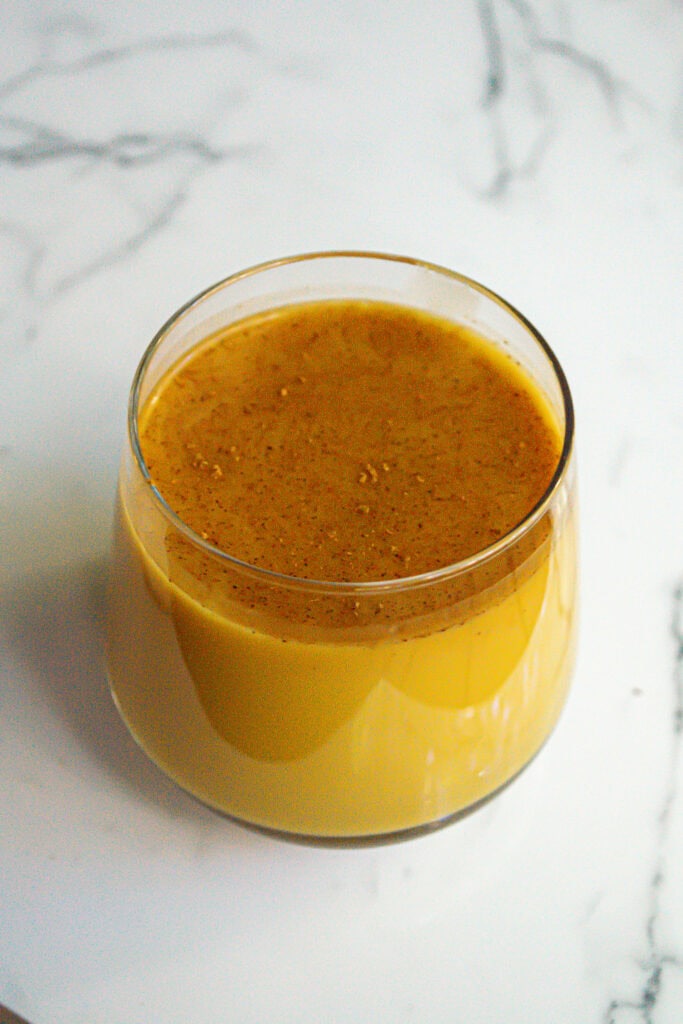 Butternut squash soup served in a clear glass on a white marble surface, creamy, smooth, and comforting autumn-inspired healthy recipe, seasonal vegetable soup, gluten-free food, vegan-friendly soup, Simply Fresh Foodie.