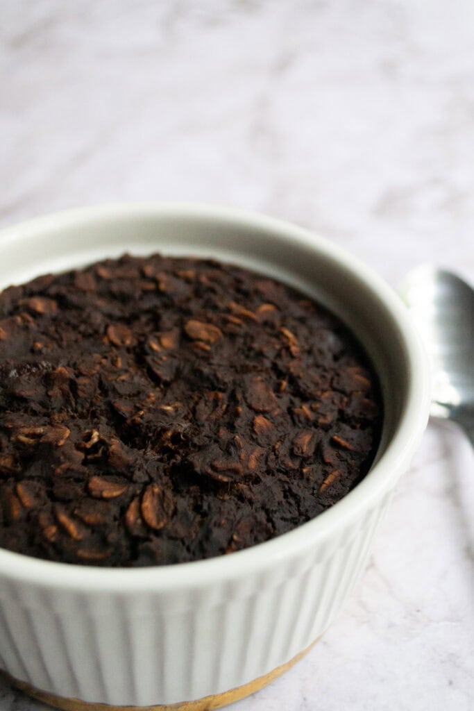 White ramekin with brownie batter baked oats inside.