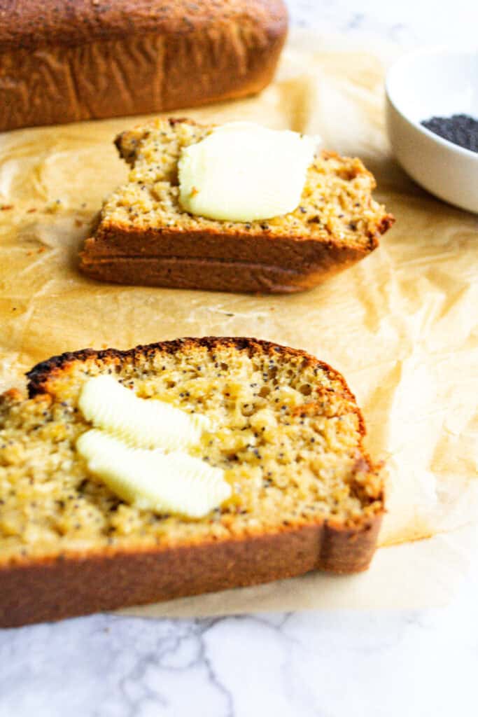 Layers of freshly baked banana bread with a buttery texture topped with melting butter, perfect for breakfast or snack.