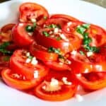Fresh tomato salad with chopped garlic and herbs, healthy and vibrant food.