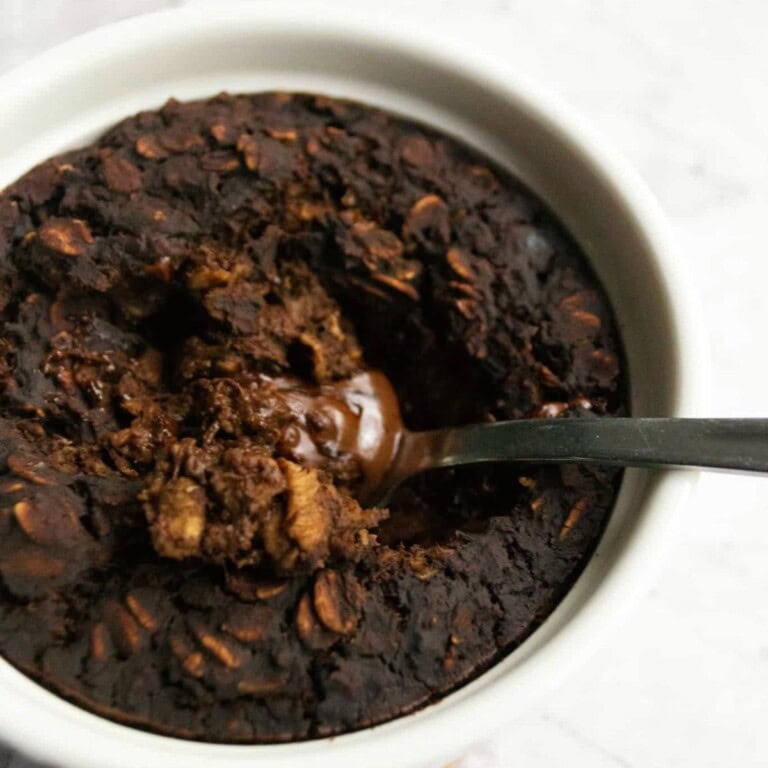 Rich, fudgy chocolate chip cookie crumble dessert with melted chocolate in a white ramekin, perfect for indulgent sweet treats and homemade baking recipes.