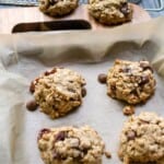 Homemade oatmeal chocolate chip cookies on parchment paper with a wooden background, freshly baked cookie close-up, delicious and wholesome snacks, perfect for snacks or desserts, Simply Fresh Foodie.