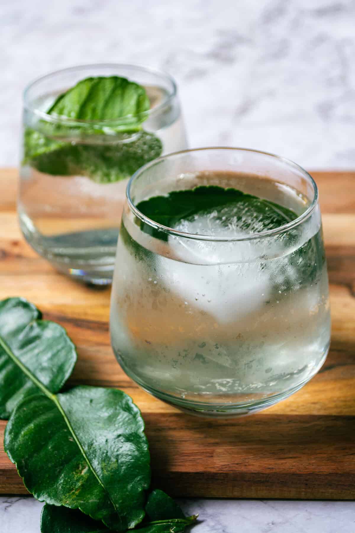 Fresh cucumber and mint infused water in clear glasses on a wooden surface, promoting healthy hydration.