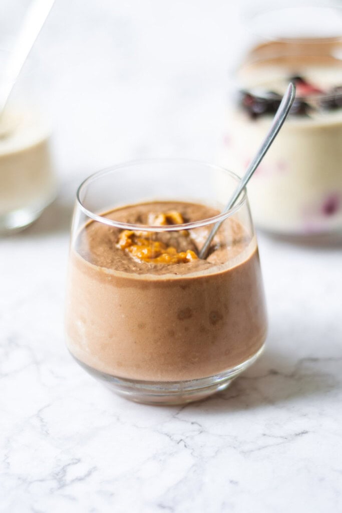 Individual photo of chocolate blended overnight oats in a cup with a spoon in it.